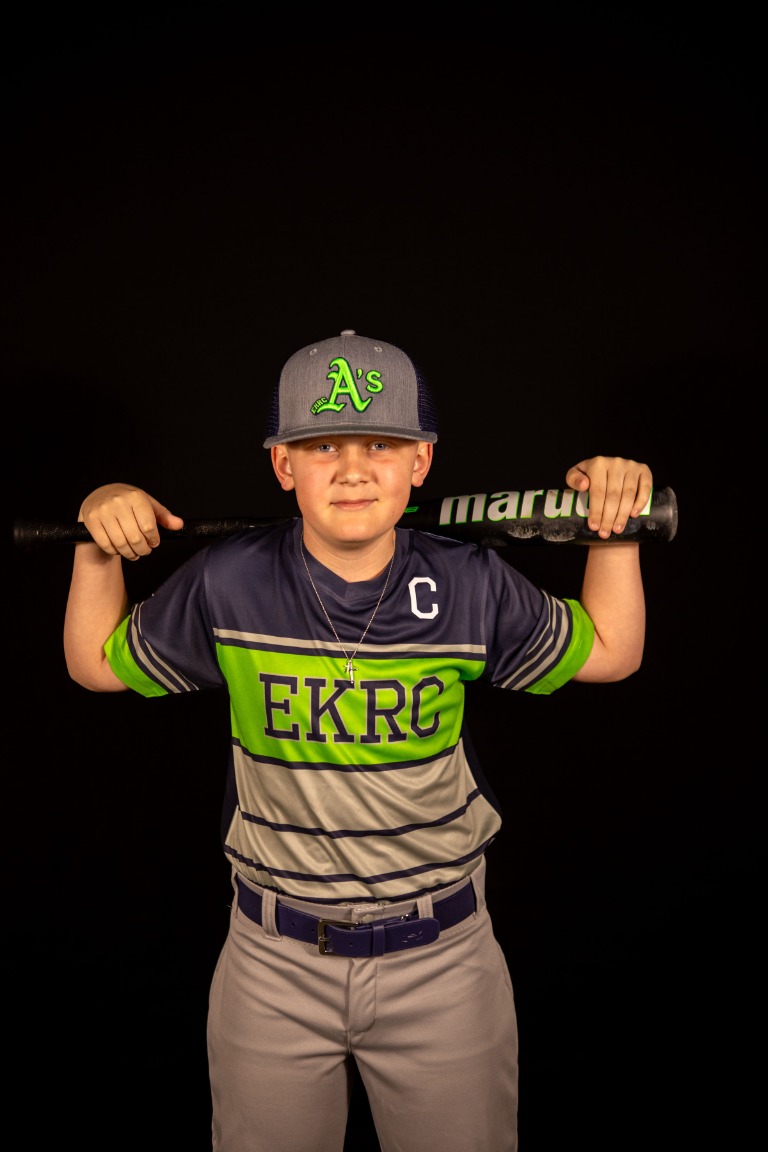 A young baseball player holding his bat
