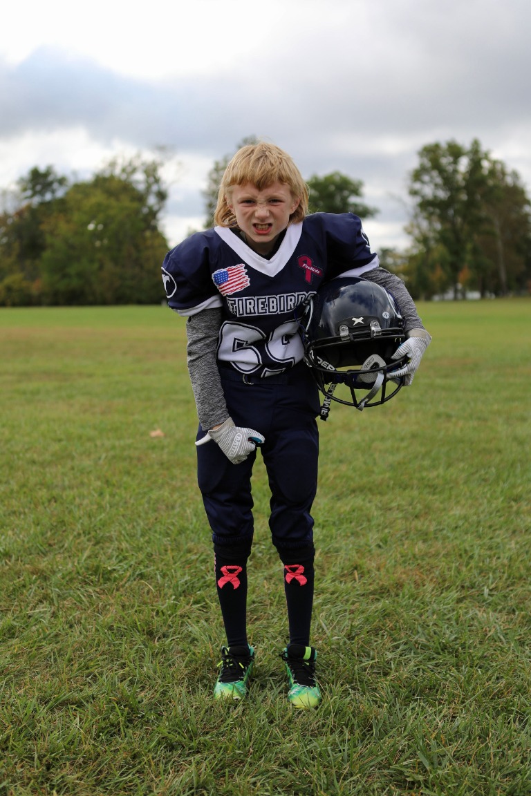 A young football player standing on the field