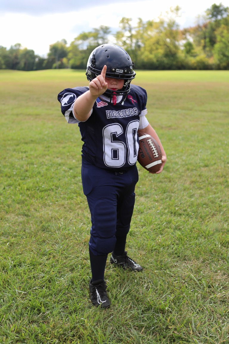 A young football player holding a ball