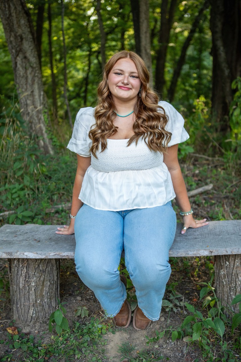 A senior sitting on a rustic bench in the woods