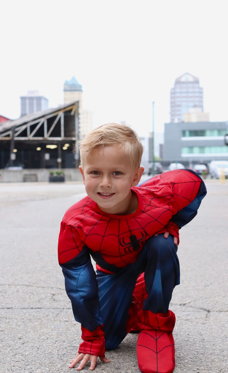 A young superhero posing on a city street
