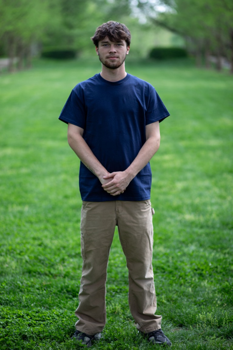 A young man standing for a relaxed outdoor portrait